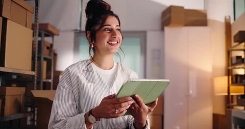 Smiling Woman Using Tablet in Warehouse Storage