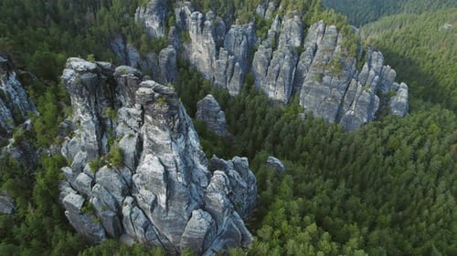 Aerial view of impressive rock formations in Bastei, Germany, surrounded by a lush green forest.