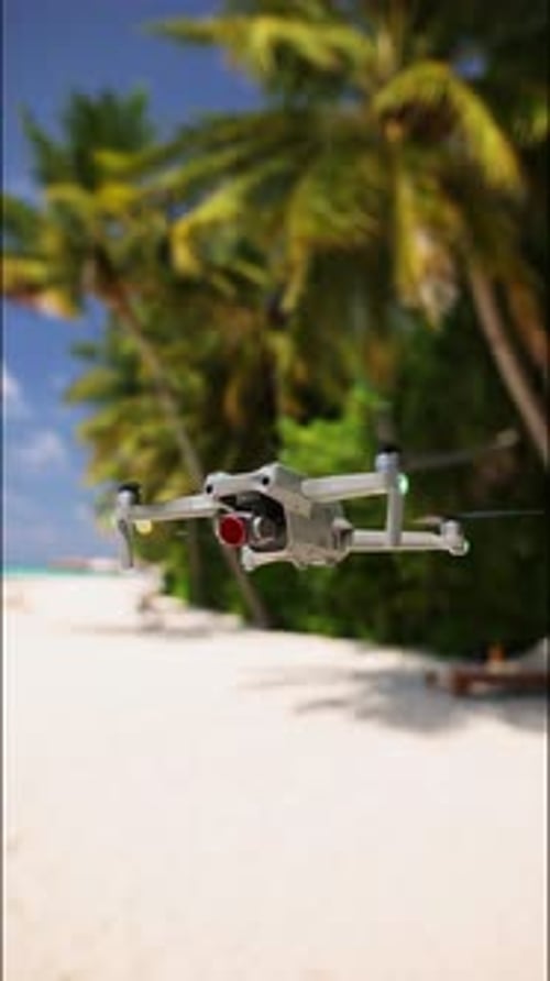 A Drone Hangs in the Air Above a Beach in the Maldives Vertical Footage