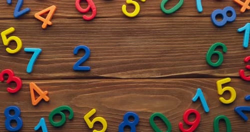 Child Hand Puts Colored Numbers 2023 New Year on Wooden Background