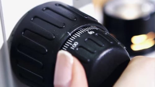 A Medical or Scientific Researcher Using a Microscope in a Laboratory Environment Close Up