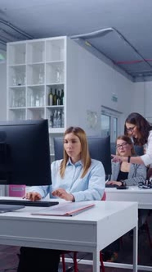 Focused Employees Working at Computers in Modern Open Plan Office Environment with Collaborative