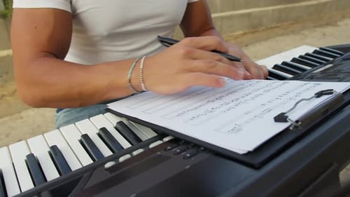 Musician Composing Music Outdoors on Electric Keyboard