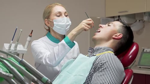 Dedicated Female Dentist Meticulously Examining Her Patient's Teeth in a Modern Dental Clinic