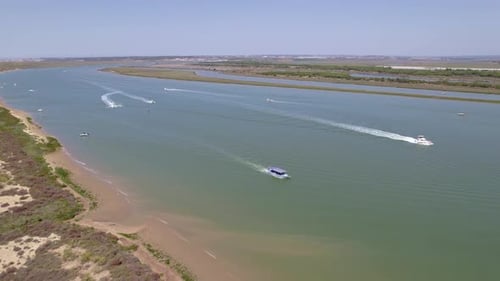 Motor boats sailing and white wakes in the estuary. Panoramic aerial view over the water. Andalusia.