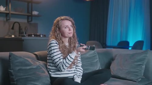 Woman Relaxing on Sofa Watching Television