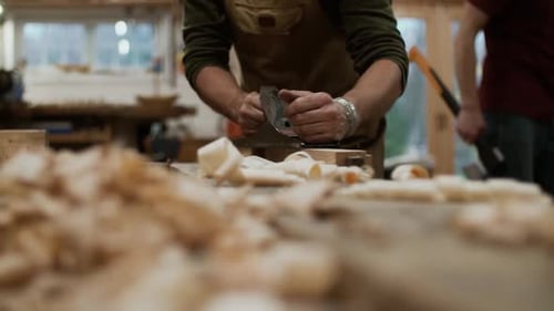 Closeup with carpenter planing the wood in workshop in slow motion.