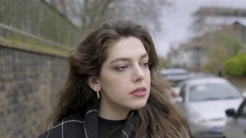 Brunette businesswoman walking into shot on sidewalk drinking coffee in central London. Slow motion