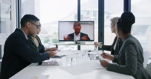 4k video footage of a group of businesspeople having a video call with a colleague in an office