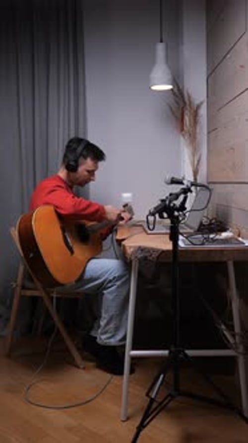 Man Plays Acoustic Guitar in Home Recording Studio