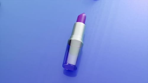 Purple Lipstick in a Transparent Tube with Silver Details Resting on a Reflective Blue Surface