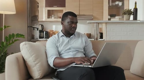 Man Working on Laptop Computer at Home