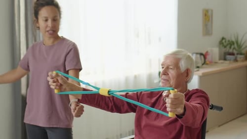 Woman Assists Senior Man with Resistance Band Exercises