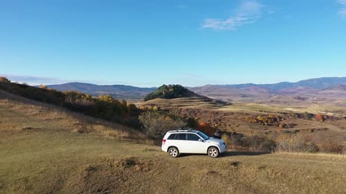 Slow motion aerial view of white 4x4 off road car in the outdoors. Freedom travel concept