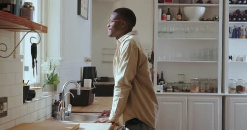 Black man, window and smile with thinking in home for reflection, decision or daydream in kitchen