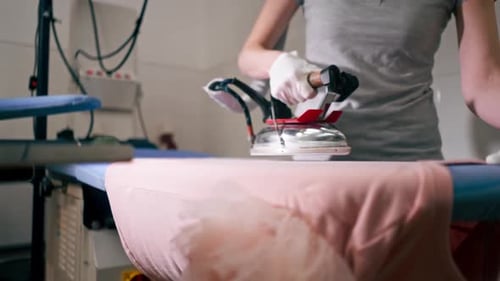 Ironing Pink Garment at Commercial Laundry