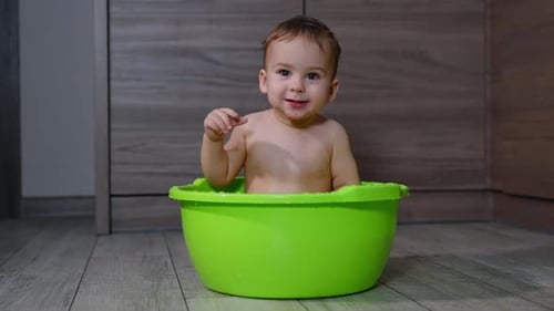 Adorable Baby Taking Bath in Green Tub