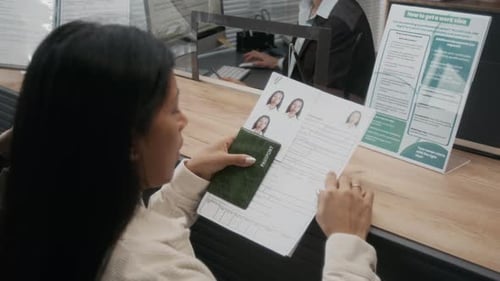 Hispanic Woman Checking Details in Application Form at Visa Center