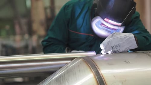 Welder, using VIG, TIG, MIG MAG method to welding stainless steel parts, close up. The welder uses a