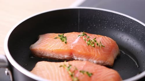 Salmon Cooking in Pan With Sprigs