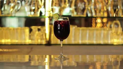 Glass of Fruity Sangria with Lime Slice on Bar Counter, Ideal for a Refreshing Drink