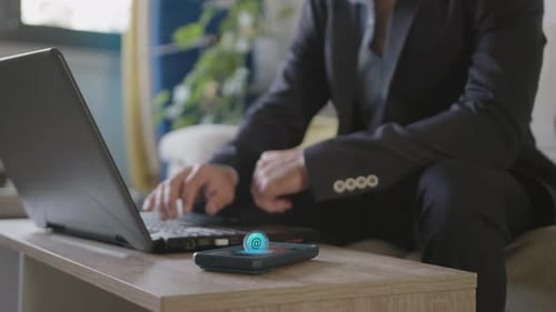 Man in Suit Using Laptop and Mobile Phone