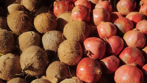 Pomegranates and Coconuts are on the Counter of the Farmer's Market