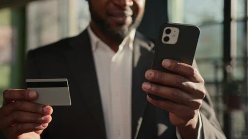 Nahaufnahme, Kreditkarte, Unbekannter afroamerikanischer Erwachsener, Mann, Geschäftsmann, Banker im Büro, Online bezahlen