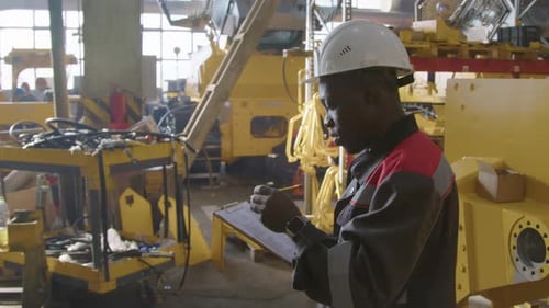 Production Engineer Checking Equipment at Machinery Factory