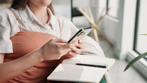 Woman Uses Cellphone While Sitting Indoors