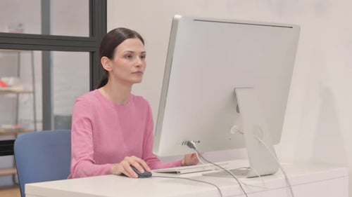 Woman Working on Computer at Desk Indoors