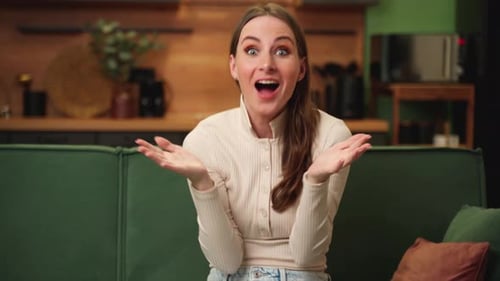 Woman Reacts with Surprise on Couch Indoors