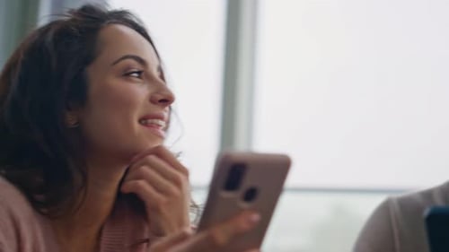 Smiling Woman and Man Use Cell Phones Indoors
