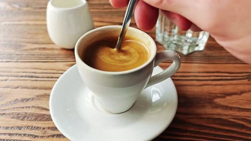 Mexido manualmente o açúcar no café