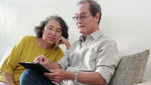 Senior Couple Uses Tablet Together at Home