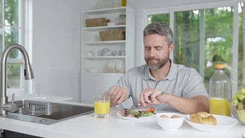 Man Eating Breakfast in Bright Modern Kitchen