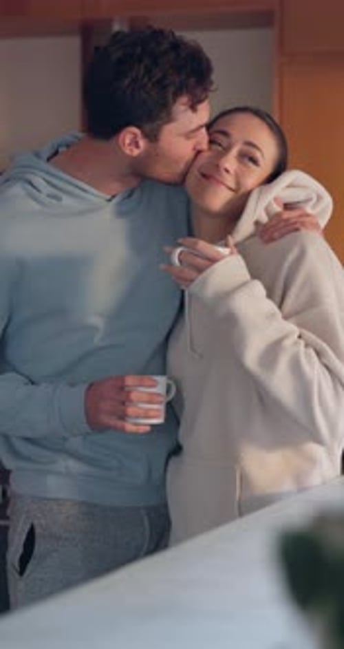 Affectionate Couple Embracing in Kitchen Setting