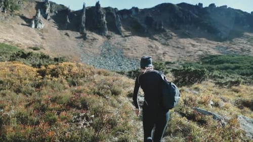 Woman Hiking on Rocky Trail Towards Mountain Peak in Autumn