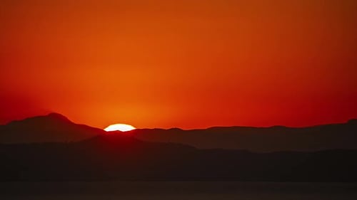 Full Moon Rising Against Red Horizon Over Mountains. Timelapse