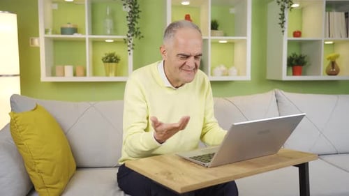 Senior Man Typing on Laptop at Home