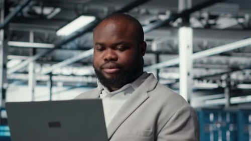 Nahaufnahme eines Ingenieurs im Serverraum mit Laptop, der Sicherheitspatches ausführt