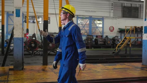 Workers in Jumpsuits Walking Inside of a Factory