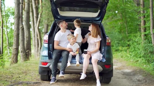 Family Relaxing in Car Trunk in Forest