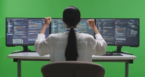 Happy Woman Developer Celebrating And Dancing While Write Code With Multiple Screens In Green Screen