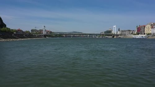 Drone goes forward over the Danube river on low altitude at the Erzsebet bridge in Budapest, Hungary