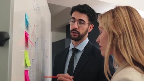 Man Explaining Data to Woman in an Office