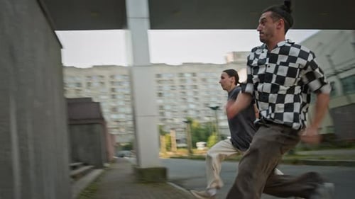 Athletic Men Doing Parkour Runs and Jumps in City