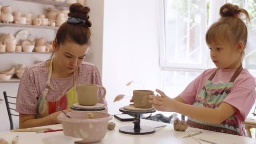 Mother and Daughter Enjoy Pottery Making Together in a Cozy Studio