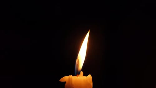 Candle Flame Flickering in the Darkness