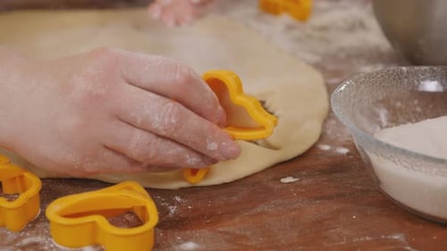 Hands Cutting Dough with Cookie Cutters